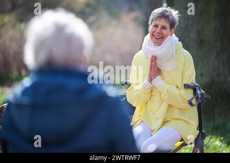 PRODUKTION - 13. März 2024, Sachsen-Anhalt, Köthen: Yogalehrerin Kathrin Fritzsche führt im Schlosspark Köthen einen Rollator-Yoga-Kurs für Senioren durch. Der Kurs bietet spezifische Übungen, die auf und außerhalb des Rollators durchgeführt werden können. Foto: Jan Woitas/dpa Stockfoto