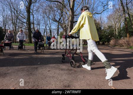 PRODUKTION - 13. März 2024, Sachsen-Anhalt, Köthen: Yogalehrerin Kathrin Fritzsche führt im Schlosspark Köthen einen Rollator-Yoga-Kurs für Senioren durch. Der Kurs bietet spezifische Übungen, die auf und außerhalb des Rollators durchgeführt werden können. Foto: Jan Woitas/dpa Stockfoto