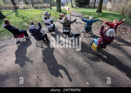 PRODUKTION - 13. März 2024, Sachsen-Anhalt, Köthen: Yogalehrerin Kathrin Fritzsche führt im Schlosspark Köthen einen Rollator-Yoga-Kurs für Senioren durch. Der Kurs bietet spezifische Übungen, die auf und außerhalb des Rollators durchgeführt werden können. Foto: Jan Woitas/dpa Stockfoto