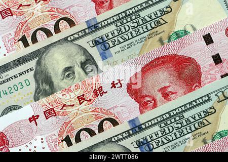 Viele Geldscheine der Volksrepublik China und der Vereinigten Staaten. PRC Yuan- und USD-Dollar-Banknoten aus nächster Nähe Stockfoto