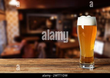 Glas mit frischem Bier auf Holztisch im Pub, Platz für Text Stockfoto