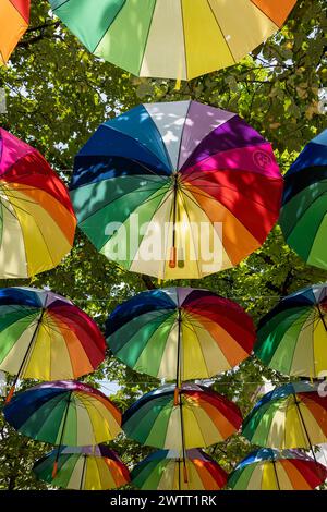 Homosexueller Stolz. Bunte Regenschirme mit Regenbogenfarben, die die LGBTQIA-Community symbolisieren, hängen über der Straße des Schwulendorfes. Paris, Frankreich Stockfoto