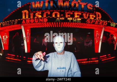 Eine Tänzerin mit weißer Maske vor Walzer bei einem Outdoor-Rave aus den 1990er Jahren in Zentralschottland Stockfoto