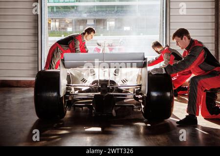 Die Boxencrew arbeitet fleißig an einem Rennwagen in der Garage vor dem Rennen. Stockfoto