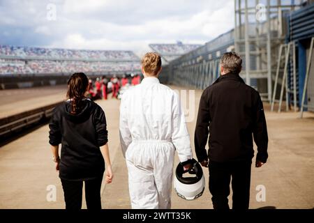 Ein Tag bei den Rennen erfüllt die Luft, während die Teilnehmer und die Crew sich auf die Strecke zubewegen. Stockfoto