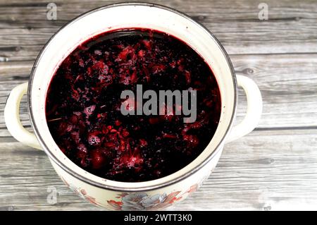 Gekochte roselkräuter in Wasser, dunkel rot-violett gefärbte Bissap Wonjo natürliche Kräuter, Blumen der Roselle Pflanze Hibiscus, die zur Herstellung von Roselle Jui verwendet wurde Stockfoto