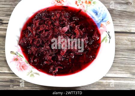 Gekochte roselkräuter in Wasser, dunkel rot-violett gefärbte Bissap Wonjo natürliche Kräuter, Blumen der Roselle Pflanze Hibiscus, die zur Herstellung von Roselle Jui verwendet wurde Stockfoto