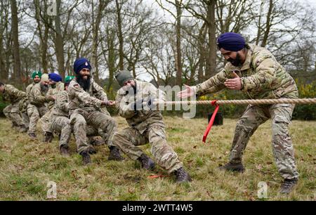 Sikh-Soldaten der Britischen Armee treten in einem Tauziehen an, als sie am Holla Mahalla Sikh-Militärfestival in der Aldershot Garrison in Hampshire teilnehmen. Das jahrhundertealte Hola Mahalla Festival feiert die Kampftraditionen der Sikh und fördert Mut, Vorbereitung und Bereitschaft. Bilddatum: Dienstag, 19. März 2024. Stockfoto