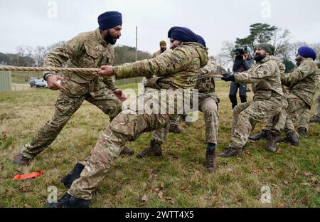 Sikh-Soldaten der Britischen Armee treten in einem Tauziehen an, als sie am Holla Mahalla Sikh-Militärfestival in der Aldershot Garrison in Hampshire teilnehmen. Das jahrhundertealte Hola Mahalla Festival feiert die Kampftraditionen der Sikh und fördert Mut, Vorbereitung und Bereitschaft. Bilddatum: Dienstag, 19. März 2024. Stockfoto