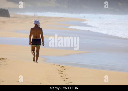 Einsamer Mann, der am Strand Playa Piedra, El Cotillo, Fuerteventura, den Kanarischen Inseln, Spanien spaziert. Stockfoto