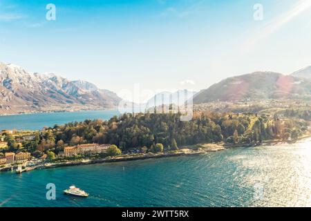 Luftaufnahme des Dorfes Bellagio am Comer See mit blauem Himmel und den Alpen im Hintergrund, Bellagio, Como, Italien Stockfoto