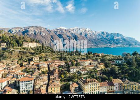 Luftaufnahme des Dorfes Bellagio am Comer See mit blauem Himmel und den Alpen im Hintergrund, Bellagio, Como, Italien Stockfoto