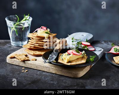 Herzhafte Pfannkuchen serviert mit einem Klecks Kräuterbutter auf einem rustikalen Holzbrett Stockfoto