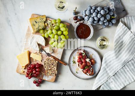 Eine Gourmet-Käse- und Obstplatte gepaart mit Wein an einem gemütlichen Nachmittag. Stockfoto