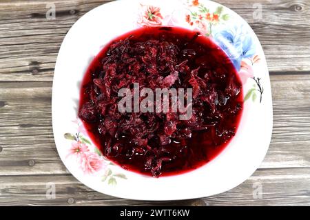 Gekochte roselkräuter in Wasser, dunkel rot-violett gefärbte Bissap Wonjo natürliche Kräuter, Blumen der Roselle Pflanze Hibiscus, die zur Herstellung von Roselle Jui verwendet wurde Stockfoto