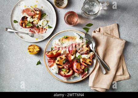 Gourmet-Mahlzeit mit gegrillten Pfirsichen und Schinken, elegant auf einem Teller serviert Stockfoto