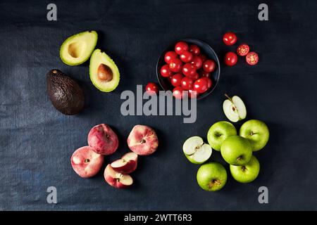 Stillleben von Avocado, Kirschtomaten, Pfirsichen und Äpfeln Stockfoto