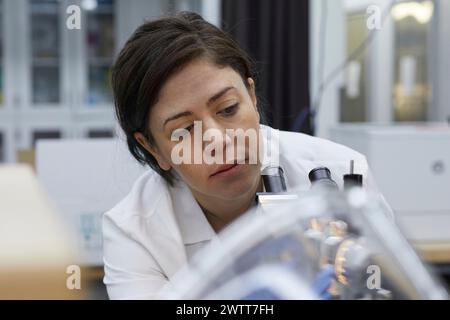 Attraktive Wissenschaftlerinnen, die mit Mikroskop auf dna testen Stockfoto