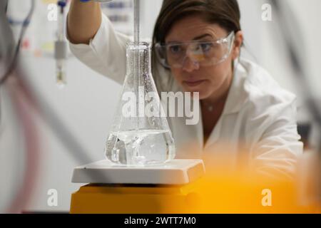 Attraktive Wissenschaftlerinnen-Prüfung mit Becher und Peppet im labor Stockfoto