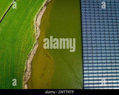 Aus der Vogelperspektive eine kontrastreiche Landschaft mit Solarpaneelen und Ackerland Stockfoto