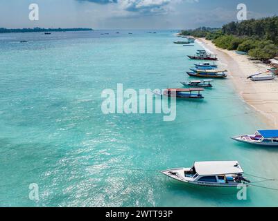 Ein ruhiger tropischer Strand mit Booten, die in klarem, blauem Wasser vertäut sind Stockfoto