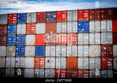 Pulsierendes Labyrinth aus gestapelten Versandcontainern unter blauem Himmel. Stockfoto