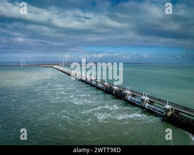 Ein ruhiger Blick auf einen langen Pier, der sich in ein ruhiges Meer unter einem bewölkten Himmel erstreckt. Stockfoto