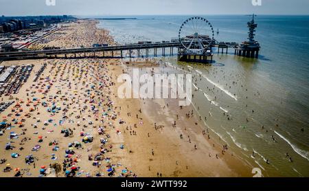 Aus der Vogelperspektive sehen Sie eine lebhafte Strandszene mit einer belebten Menschenmenge und einem berühmten Pier Stockfoto