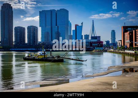 Die geschäftige Skyline der Stadt vor einem klaren blauen Himmel mit einem Schlepper auf dem Fluss Stockfoto