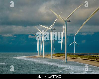 Windturbinen stehen hoch am Meer unter einem dramatischen Himmel Stockfoto