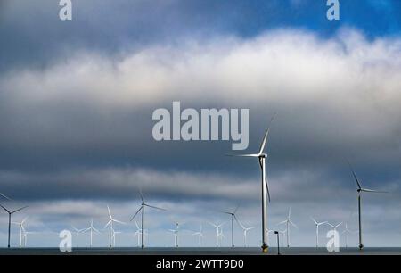 Windturbinen stehen hoch vor einem dramatisch bewölkten Himmel Stockfoto