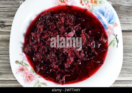 Gekochte roselkräuter in Wasser, dunkel rot-violett gefärbte Bissap Wonjo natürliche Kräuter, Blumen der Roselle Pflanze Hibiscus, die zur Herstellung von Roselle Jui verwendet wurde Stockfoto