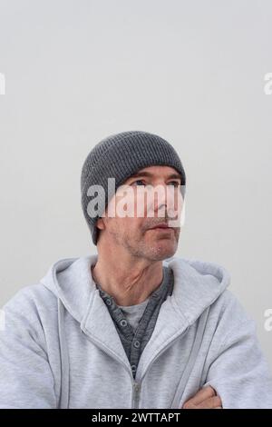Porträt eines gutaussehenden reifen Mannes, der einen Strickmütze trägt und wegschaut Stockfoto