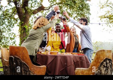 Verschiedene Freunde stoßen auf Partys an - multikulturelle junge Leute, die Weingläser anstoßen - fröhliches Treffen im Freien Stockfoto