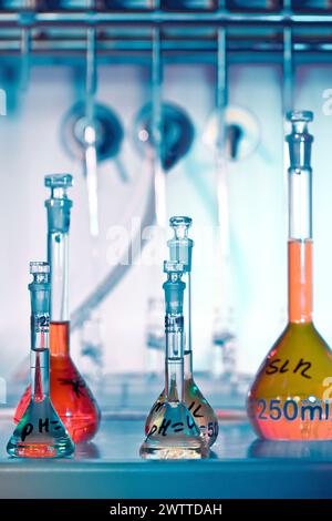 Bunte Chemiegläser auf einem Labortisch Stockfoto