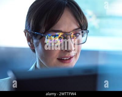 Weibliche STAMMWISSENSCHAFTLERIN mit künstlicher Intelligenz, um ein molekulares Modell einer chemischen Verbindung auf einem Computerbildschirm zu entwerfen. Stockfoto