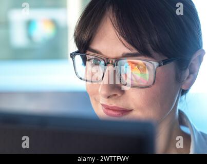 Professionelle Frauen entwerfen ein Tortendiagramm auf einem Computer, um Unternehmensstatistiken zu veranschaulichen. Stockfoto