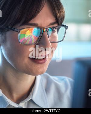 Professionelle Frauen entwerfen ein Tortendiagramm auf einem Computer, um Unternehmensstatistiken zu veranschaulichen. Stockfoto