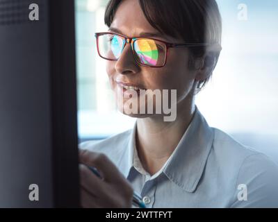 Professionelle Frauen entwerfen ein Tortendiagramm auf einem Computer, um Unternehmensstatistiken zu veranschaulichen. Stockfoto