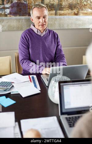 Mann in lila Pullover bei einem Geschäftstreffen. Stockfoto