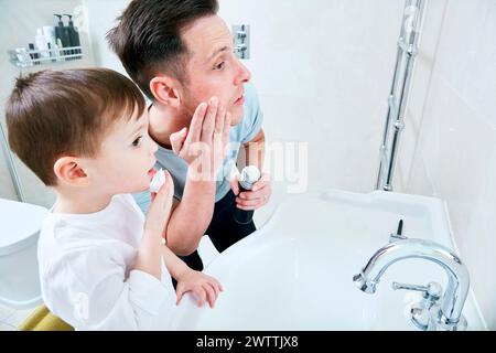 Vater und Sohn zusammen im Bad die Zähne putzen Stockfoto