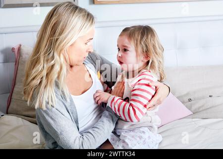 Großmutter tröstet weinendes Kind auf einer Couch Stockfoto