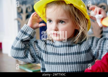 Kind in einem gelben Schutzhelm Stockfoto