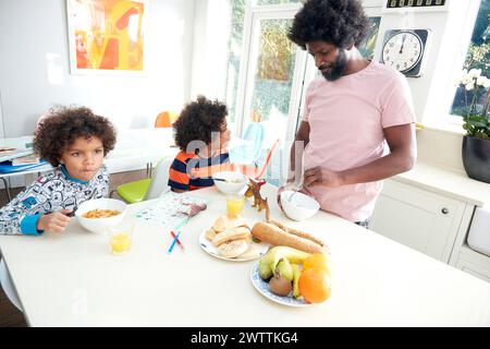 Vater und Kinder frühstücken zusammen Stockfoto