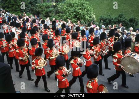 1960er Jahre, historisch, Blick von oben auf die Band der Grenadier Guards in voller Uniform und traditioneller Pelzmütze, bekannt als Bärenfelle, die ihre Instrumente spielen, während sie beim Orden des Garters und der Prozession in Windsor Castle, Berkshjire, England, Großbritannien marschieren. Eine der ältesten und berühmtesten Militärbands mit einer langen Geschichte, die bis 1665 zurückreicht, spielt die Band als Teil der Bands der Household Division bei wichtigen britischen Zeremoniellen und königlichen Veranstaltungen. Stockfoto