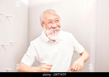Senior Mann mit Bart, der drinnen lächelt Stockfoto