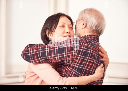 Ein älterer Mann, der eine Frau mittleren Alters umschließt Stockfoto