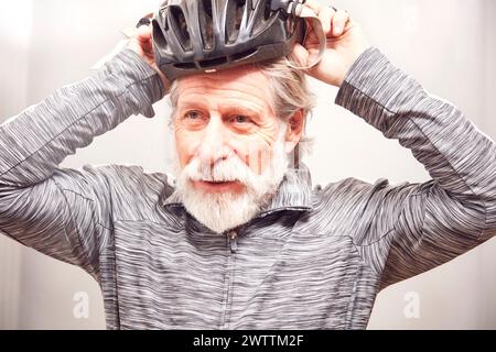 Senior-Mann, der einen Fahrradhelm aufsetzt. Stockfoto