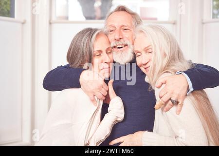 Drei glückliche Seniorinnen umarmen und lächeln Stockfoto