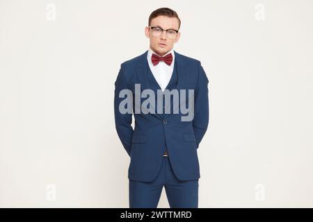 Mann in blauem Anzug mit roter Fliege und Brille Stockfoto